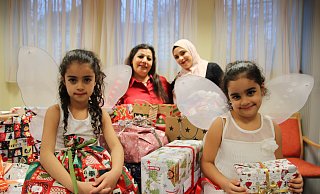 Marie und ihre Schwester Rita (v. l.) zeigen gemeinsam mit Salwa Al-Mahmod und Marah Halimeh die vielen schönen Geschenke, die Herforderinnen und Herforder gepackt haben. - Susanne Blersch