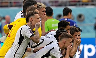 Die deutschen Spieler halten sich beim Teamfoto vor dem Spiel die Hände vor den Mund. - Eugene Hoshiko/AP/dpa