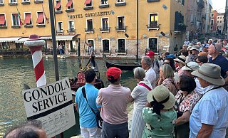 Es ist voll in Venedig: Eine Besuchergruppe wartet auf das Eintreffen von Gondeln. - dpa