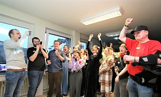In der Linken-Parteizentrale in Paderborn recken die Besucher der Wahlparty nach der Prognose die Arme in die Höhe. - Rajkumar Mukherjee