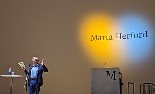 Ein Herz leuchtet in den Farben der Ukraine während Wladimir Kaminer im Marta liest. - Susanne Barth