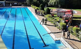 Die Feuerwehrleute in Aktion: Ein Teil des Wassers aus dem Becken des Warburger Waldbades sollte abgepumpt werden. - Dieter Scholz