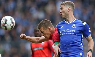 Vereinslegenden unter sich: Bielefelds Fabian Klos (r.) kommt im Kampf um den Ball mit Uwe Hünemeier (l.) aus Paderborn zu spät. - picture alliance/dpa