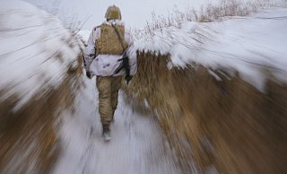 Ein ukrainischer Soldat geht an der Frontlinie durch einen Graben. - Foto: Vadim Ghirda/AP/dpa