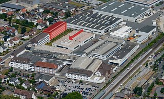 Das rot markierte Gebäude zeigt das geplante Forschungs- und Entwicklungszentrum, das entlang der Borriesstraße entstehen soll. Der Pfeil weist auf die Halle (hier noch mit der alten Lichtkuppel) für die neue Pressenanlage. - Miele