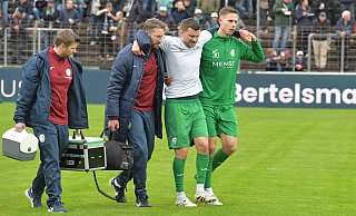 Ein ganz bitterer Moment: Noch vor dem Anpfiff des Derbys gegen den SC Wiedenbrück wird Björn Rother (m.), Kapitän des Fußball-Regionalligisten FC Gütersloh, unter anderem von Mitspieler Jannik Borgmann (r.) vom Platz begleitet. Der 29-Jährige hat sich zuvor beim Warmmachen schwer verletzt. - Jens Dünhölter