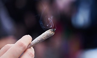 Eine Frau hält einen Joint in der Hand: Cannabis wird von der Liste der verbotenen Substanzen gestrichen. - Annette Riedl/dpa