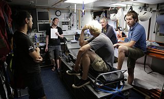 (v.l.) Diego Weber, Axel Grafsmann, Welf Seyer (auf der Liege), Ingo Werth und Julius Ruper besprechen auf der "Sea Watch 2" die Lage, nachdem ein anderes Flüchtlingshelfer-Boot geentert wurde. - Bastian Schlange