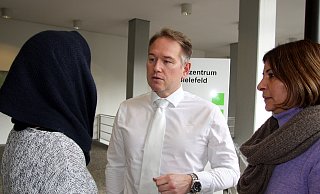 Wegen ihres entstellten Gesichts trägt das Opfer vom Jahnplatz einen Schal um den Kopf. Anwalt Carsten Ernst und Dilek Dogan-Alagöz von der psychosozialen Prozessbegleitung stehen ihr zur Seite. - Jens Reichenbach
