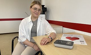 Ein Armband mit Notruf-Knopf und eine Basisstation: Franziska Fronzeck vom DRK Herford-Land demonstriert das neue Angebot des Kreisverbandes. - Shannon-Lee Bendig
