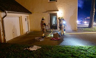 Einsatzkräfte der Feuerwehr Paderborn löschen Reste des Türblattes ab, das auf den Herd gelegt worden war. - Ralph Meyer