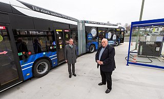 Bürgermeister Michael Dreier (l.) und Padersprinter-Geschäftsführer Peter Bronnenberg stehen vor dem neuen E-Bus, rechts ist die Auflade-Station zu sehen. - Niklas Tüns
