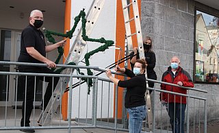 Carsten Müller (v. i.), Vicky Ahldag, Judyta Herzberg und Werner Brakensiek vom Arbeitskreis der Kaufmannschaft bringen in der Burgstraße einen Weihnachtsstern an. - Britta Bohnenkamp-Schmidt