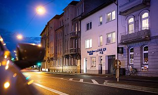 Das Islamische Zentrum Bielefeld an der August-Bebel-Straße (Gebäude mit blauer Schrift an der Fassade) grenzt an beiden Seiten direkt an Wohnbebauung an. Schallimmissionen sind deshalb mitunter ein Problem. Das soll jetzt gelöst werden. - Mike-Dennis Müller