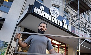 Kojie Ali zeigt die Halterung, die an seinem Geschäft am Oberntorwall in Bielefeld aus der Decke gerissen worden ist. - Oliver Krato