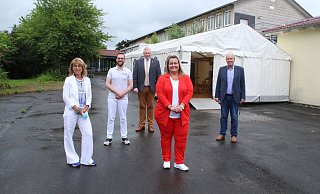 Stadtsprecherin Sabine Hasenbein (v. l.), Apotheker Hauke Bitterberg, Bürgermeister Daniel Hartmann, Projektleiterin Nadine Nolte und Wirtschaftsförderer Volker Rodermund vor dem Nachsorgezelt hinter dem Impfgebäude der ehemaligen Förderschule in Lütmarsen. - Burkhard Battran