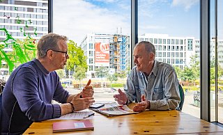 Rentner Hans-Jürgen Brinkmann ist der erste Gast von NW-Redakteur Stefan Brams bei den diesjährigen Sommergesprächen im Grünen Würfel. Im Hintergrund das neue NW-Medienhaus (rechts). - Mike-Dennis Mueller