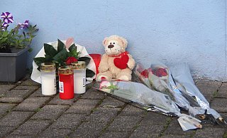 Blumen, Kerzen und ein Teddy wurden als Zeichen der Trauer vor dem Haus abgelegt. - Burkhard Battran