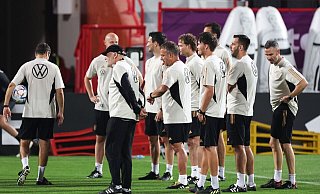 Das deutsche Trainer- und Betreuerteam steht mit Bundestrainer Hansi Flick (M) beisammen. - Christian Charisius/dpa