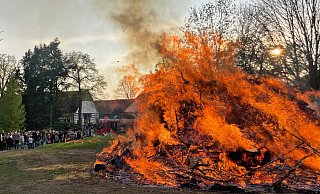 Hell lodern die Flammen auf dem Hof Lange in Belke-Steinbeck, die Besucher schauen mit einigem Sicherheitsabstand zu. - Stefanie Boss
