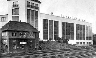 Moderner Industriebau: Einen starken Kontrast bilden das längst abgerissene alte Stellwerk der Bahn zu der Architektur des weiß gestrichenen Bauwerks des Maschinenbauunternehmens, das an dieser Stelle aber nicht mehr zu Hause ist. - Foto: Georg Heese (Kommunalarchiv)