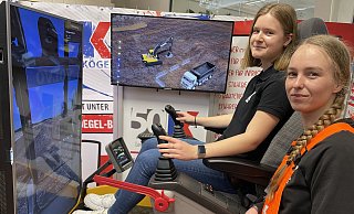 Baggern fürs Bauen: Marie Pratsch probiert unter der Anleitung von Julia Schumacher, Azubi im Unternehmen Kögel, einmal aus, was man mit so einer Baumaschine machen kann, die hier von einem Computer gesteuert wird. - Elke Niedringhaus-Haasper