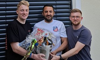 Ein silberner Pot für den Sieger: Florian Finke (l.) und Fynn Salam (r.) gratulieren dem Bezirksliga-Tippspiel-Sieger Ümüt Gözlükcü von der SG FA Herringhausen-Eickum. - privat