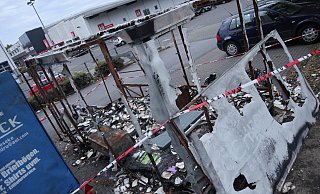 Parkplatz-Ruine: Der abgebrannten "Bücherwurm"-Anhänger fällt den Kunden der umliegenden Märkte und des Ärztehauses auf. Das Absperrband der Polizei ist noch da. Die Ermittlungen sind aber abgeschlossen. - Jens Reddeker
