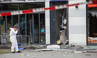 Eine Expertin der Bielefelder Spurensicherung fotografiert den zerstörten Geldautomaten. - Niklas Tüns