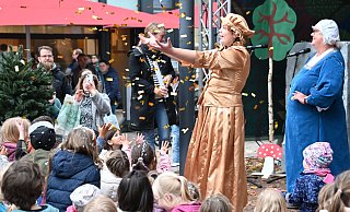 Lydia Dabringhausen als Frau Holle läss mit Mia Sandfort (als Goldmarie) und Lina Sonneborn (als Pechmarie) auf der Marktplatzbühne Federn und Süßigkeiten schneien. - Thomas Kube