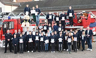 Alle ausgezeichneten Jugendfeuerwehrmitglieder mit den Gästen der Versammlung an der Höxteraner Drehleiter. - FFW Höxter/Thomas Kube
