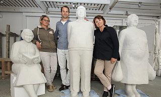 Weil die Alltagsmenschen, die am Rathaus stehen werden, eine Überraschung werden sollen, positioniert sich die Künstlerfamilie Laura Lechner (v. l.), Jan Illerhues und Christel Lechner um Figuren, die derzeit im Atelier überarbeitet werden. - Sigurd Gringel