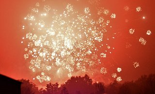 Im diesigen Abendhimmel über dem Pollhansplatz zeichnen Feuerbälle, Fontänen und Herzen eindrucksvolle Bilder. Die Pyrotechniker haben das Feuerspektakel vorbereitet. Untermalt wird es mit Musik. - Karin Prignitz