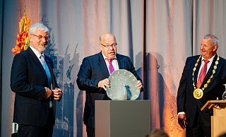 Bundeswirtschaftsminister Peter Altmaier (Mitte), bekommt von Geschäftsführer Peter Gödde (l.) und Vorsitzenden Mickel Biere den Libori-Pfau verliehen. - Besim Mazhiqi