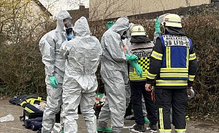 Die Feuerwehrleute müssen Schutzanzüge anlegen, um sich im Gebäude des Hallenbads vor möglicherweise ausgetretenem Chlorgas zu schützen. - Paul Brinkmann