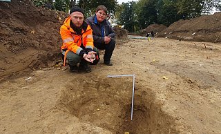 Sebastian Düvel, wissenschaftlicher Referent von der Außenstelle Bielefeld, und Grabungsleiterin Dr. Eva Manz vor einem gut 50 Zentimeter tiefen Raubgrabungsloch, in dem nur noch wenige Scherben zurückgeblieben sind. - Archäologie am Hellweg eG/Christoph Storz
