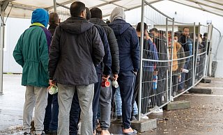 Flüchtlinge warten in einer Aufnahmestelle auf die Essensausgabe: Die meisten neuen Asylbewerber kamen im vergangenen Jahr aus Syrien. - Stefan Puchner/dpa