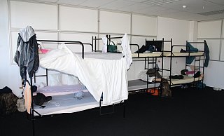 Rückzugsort: Viele Familien haben die Gitterbetten zusammengeschoben und abgehängt, um sich etwas Privatsphäre zu sichern. - Birger Berbüsse