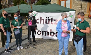 Die Schützen-Throndamen Inga Gnaß, Kerstin Peters (v. l.) und Corinna Höhne (r.) bieten auf dem Rathausplatz Lose an. Gerda Moosig ist sofort dabei. Hinter ihnen stehen die Schützen Raphael Peters und Markus Höhne (v. l.). - Karin Prignitz