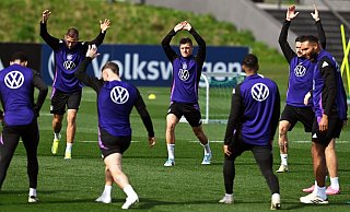 Die deutschen Nationalspieler führen im Training Dehnübungen durch. - Arne Dedert/dpa