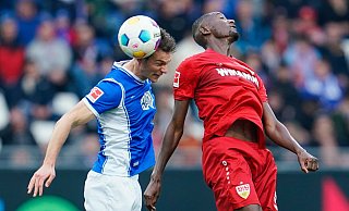 Stuttgarts Torschütze Serhou Guirassy (r) im Kopfballduell mit dem Darmstädter Christoph Zimmermann. - Ursula Düren/dpa