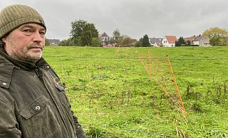 Stefan Pade vermisst mehrere hundert Meter Weidezaun. Einen Teil der Wiese hat er nun neu in Orange bepflockt. - Nicole Sielermann