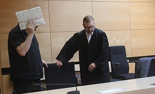 Der 48-Jährige verdeckt sein Gesicht mit einer Mappe, er sitzt in U-Haft. Der Mann wird von Martin Mauntel vertreten. - Florian Weyand