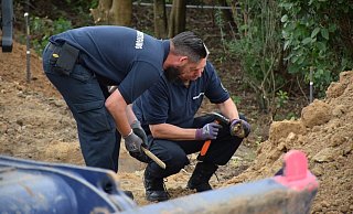 Mit vorsichtigen Hammerschlägen beseitigen die beiden Männer des Kampfmittelräumdienstes das Fundstück von Dreck. - Ilja Regier