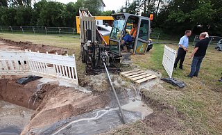 Ein Bohrer treibt das Rohr für die neue Wasserleitung zum Wasserwerk Porta Westfalica unter der Weser hindurch. Im Hintergrund begutachten Stadtwerkechef Andreas Schwarze und Wassermeister Friedrich Marks die Baustelle. - Jörg Stuke