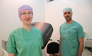 Oberärztin Eva Kunzmann und Fadi Nazha (Leitender Oberarzt der Klinik für Urologie am Brüderkrankenhaus St. Josef Paderborn) operieren an der Da-Vinci-Konsole.Oberärztin Dr. Eva Kunzmann überwacht als assistierende Urologin die Arme desda Vinci. Im Hintergrund operiert der Leitende Oberarzt Dr. Fadi Nazha an derKonsole. - BBT-Gruppe Oberärztin Eva Kunzmann und Fadi Nazha (Leitender Oberarzt der Klinik für Urologie am Brüderkrankenhaus St. Josef Paderborn) operieren an der Da-Vinci-Konsole.Oberärztin Dr. Eva Kunzmann überwacht als assistierende Urologin die Arme desda Vinci. Im Hintergrund operiert der Leitende Oberarzt Dr. Fadi Nazha an derKonsole. - BBT-Gruppe