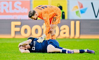 Paderborns Sven Michel hält sich nach dem vermeintlichen Foul im Strafraum den Kopf. Herthas Torhüter Marius Gersbeck muntert ihn auf. - Besim Mazhiqi