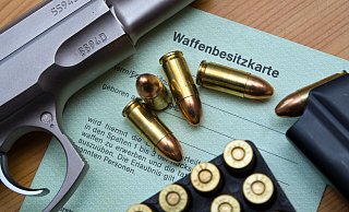Eine Kaliber 9 mm Pistole, Patronen und ein Magazin liegen in unserem Symbolbild auf einer Waffenbesitzkarte. Sie dokumentiert, welche Waffen sich im Eigentum einer Person befinden. - picture alliance/dpa