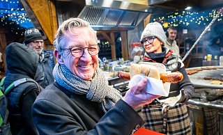 Oliver Münchow genießt eine Krakauerwurst vom Stand von Christina Schneider auf dem Altstädter Kirchplatz. - Sarah Jonek
