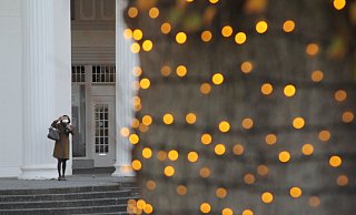Eine Frau fotografiert sich vor der Wandelhalle im weihnachtlich beleuchteten Kurpark. - Ulf Hanke